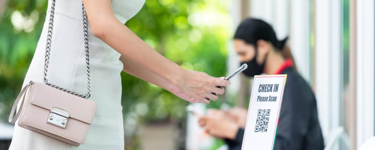 woman using phone to scan a qr code and check in