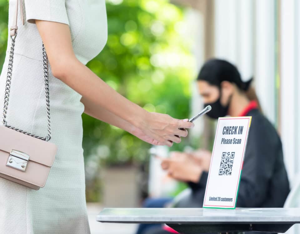 woman using phone to scan a qr code and check in